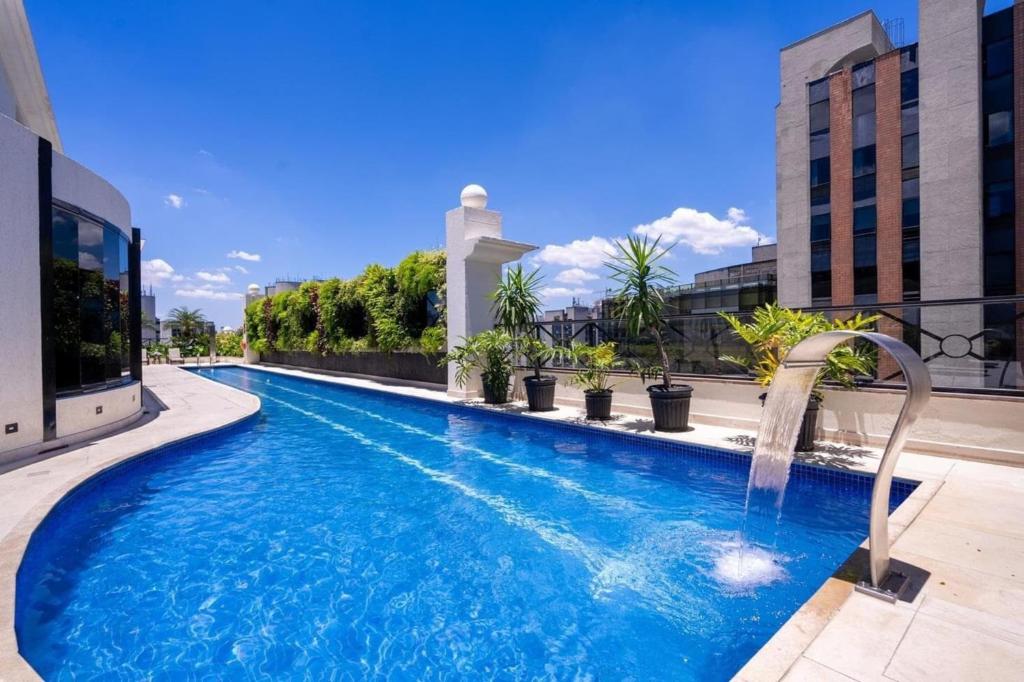 a swimming pool with a water fountain on a building at Intercity São Paulo Berrini in São Paulo