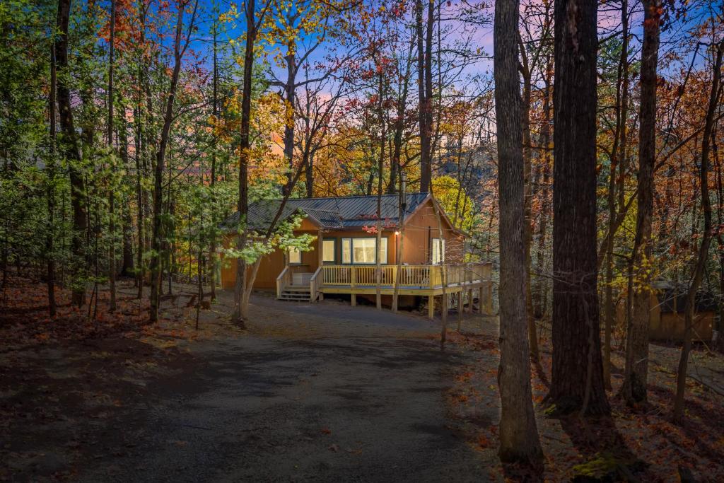 a log cabin in the middle of a forest at Cabin at Sleepy Creek - Creek Access, Wifi, Pet Friendly, Fire Pit, Charcoal Grill, Screen Porch, Wood Stove, Deck, Family Friendly in Berkeley Springs
