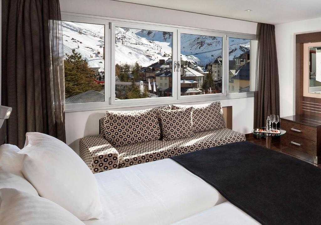 ein Wohnzimmer mit einem Sofa und einem großen Fenster in der Unterkunft Meliá Sol y Nieve in Sierra Nevada