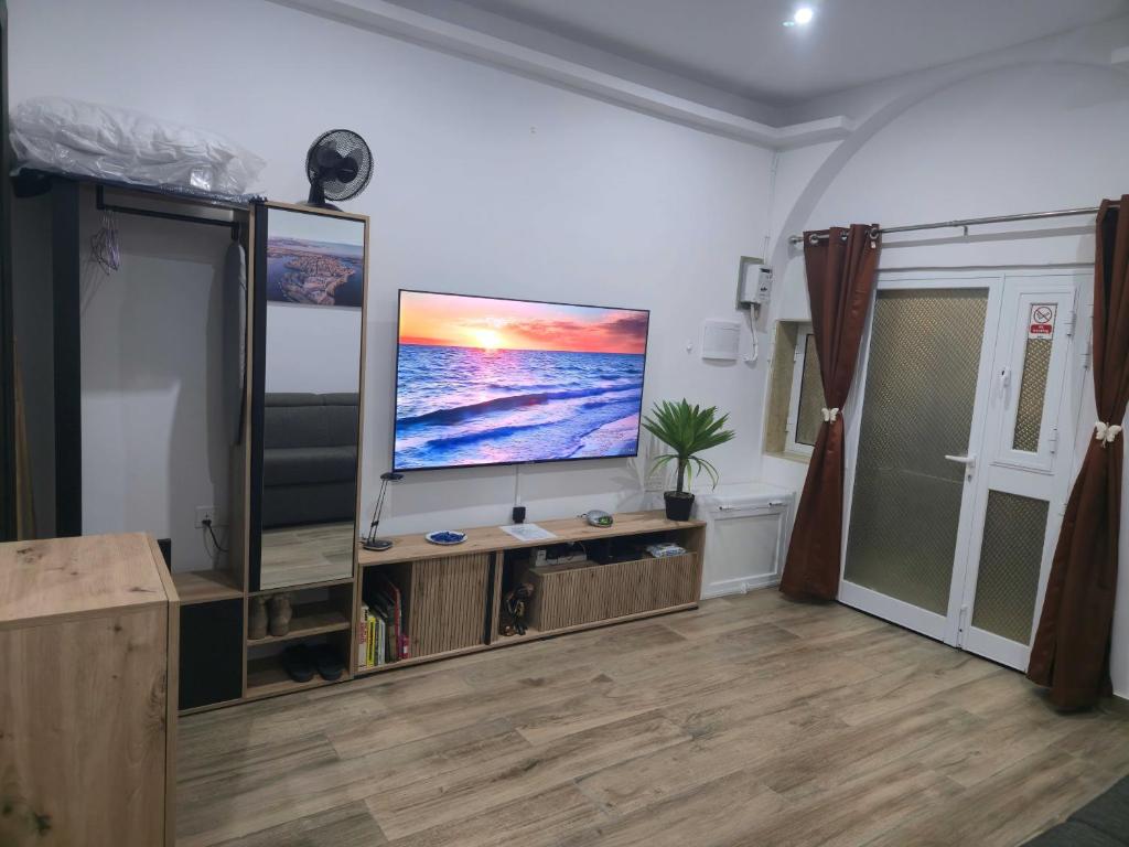 a living room with a flat screen tv on a entertainment center at Studio Groundfloor Apartment in Il-Gżira