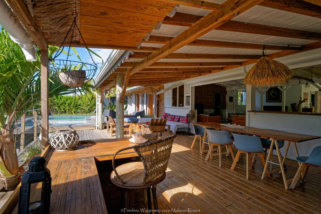 an open patio with a table and chairs on a deck at Makiese Resort in Saint-François