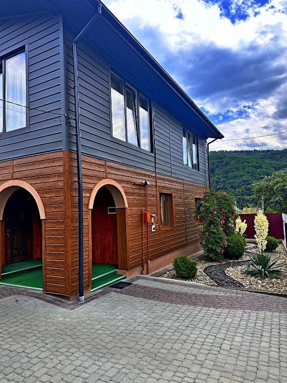 a large house with a wooden facade and a courtyard at N V New View in Yaremche