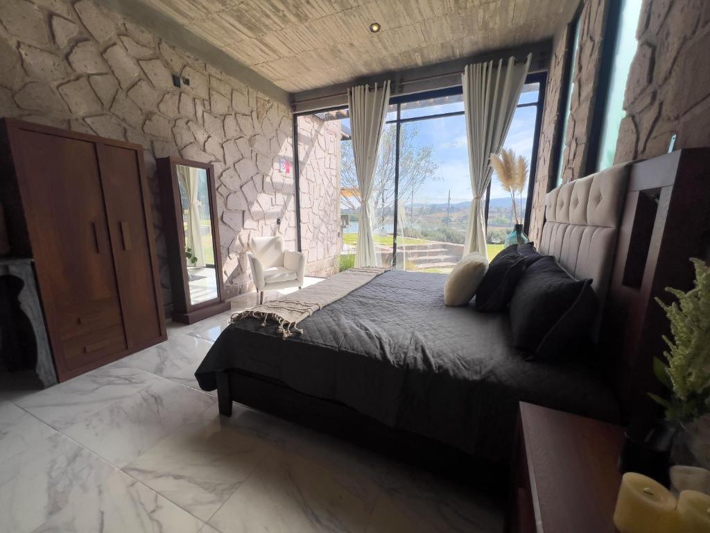 a bedroom with a bed and a large window at Dos Aguas Hotel Boutique in Encinillas