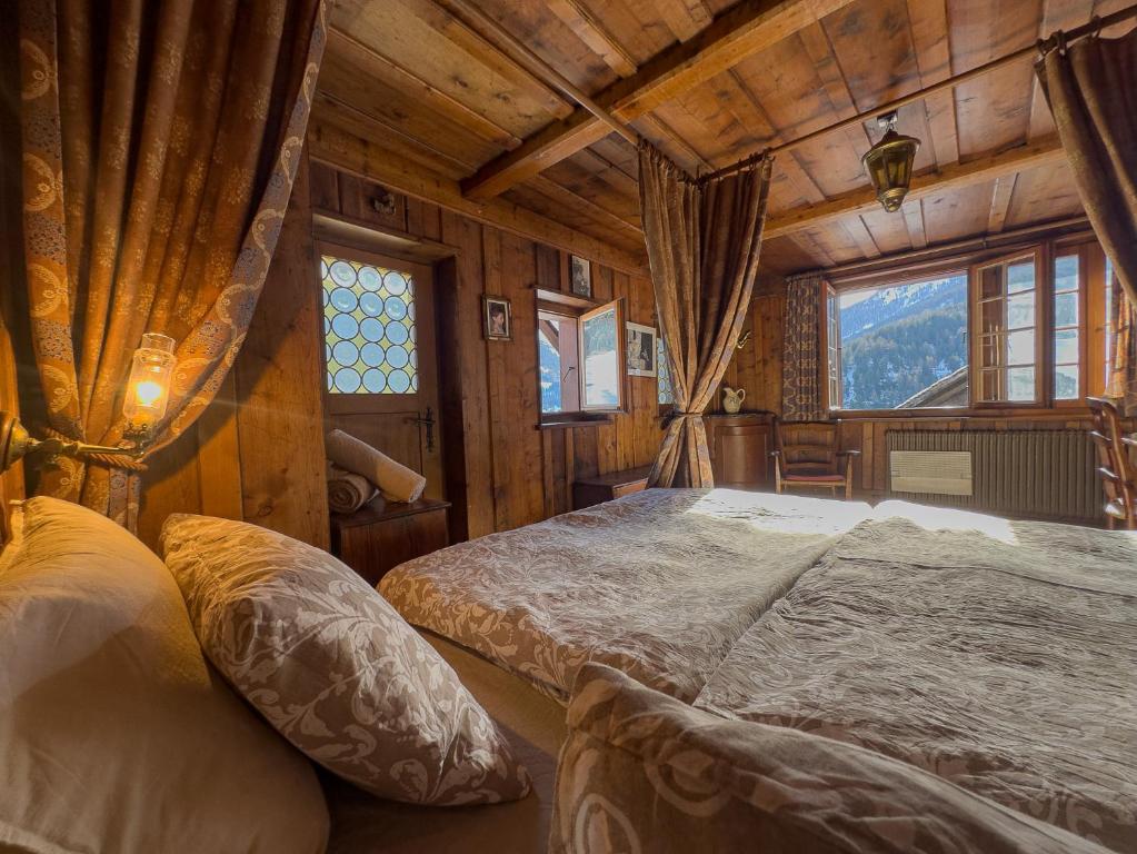 a bedroom with a bed in a wooden room at Chalet Le Zirizui - Authentique refuge alpin avec vue imprenable in Liddes