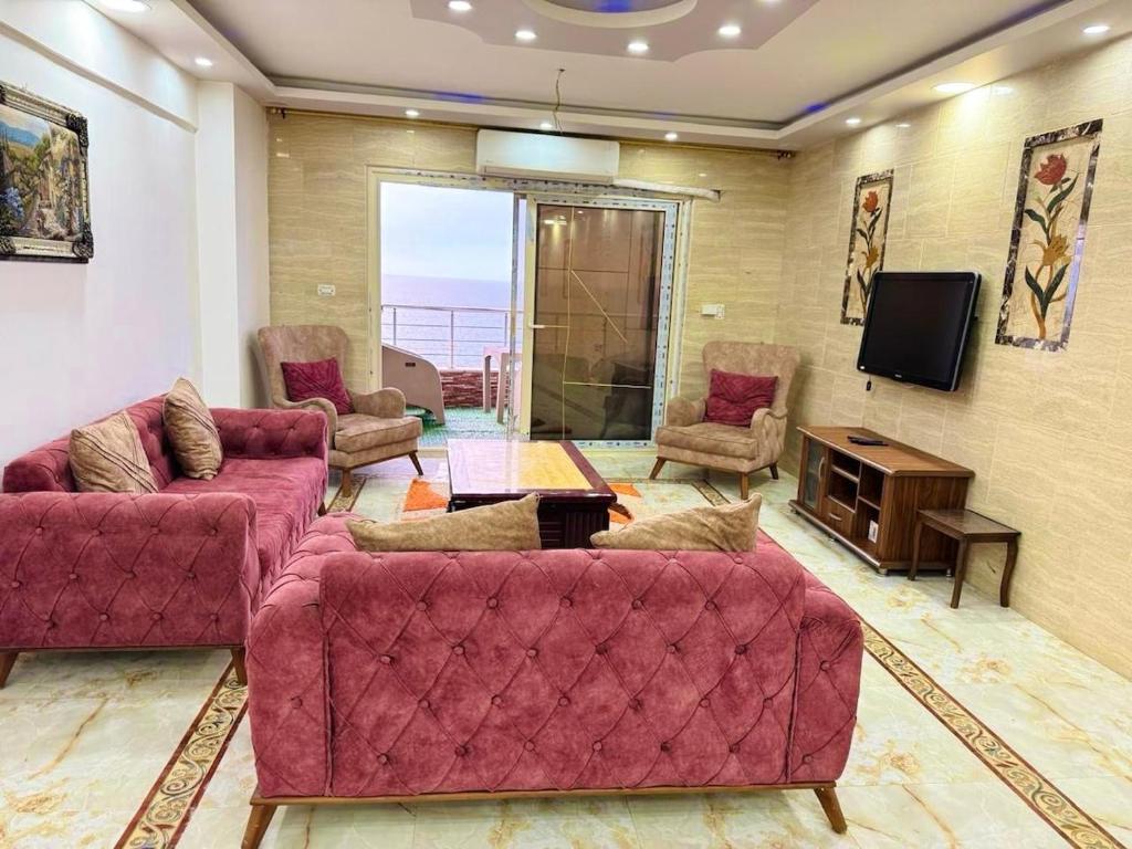 a living room with two couches and a tv at Apartment 18 Maspero in Alexandria