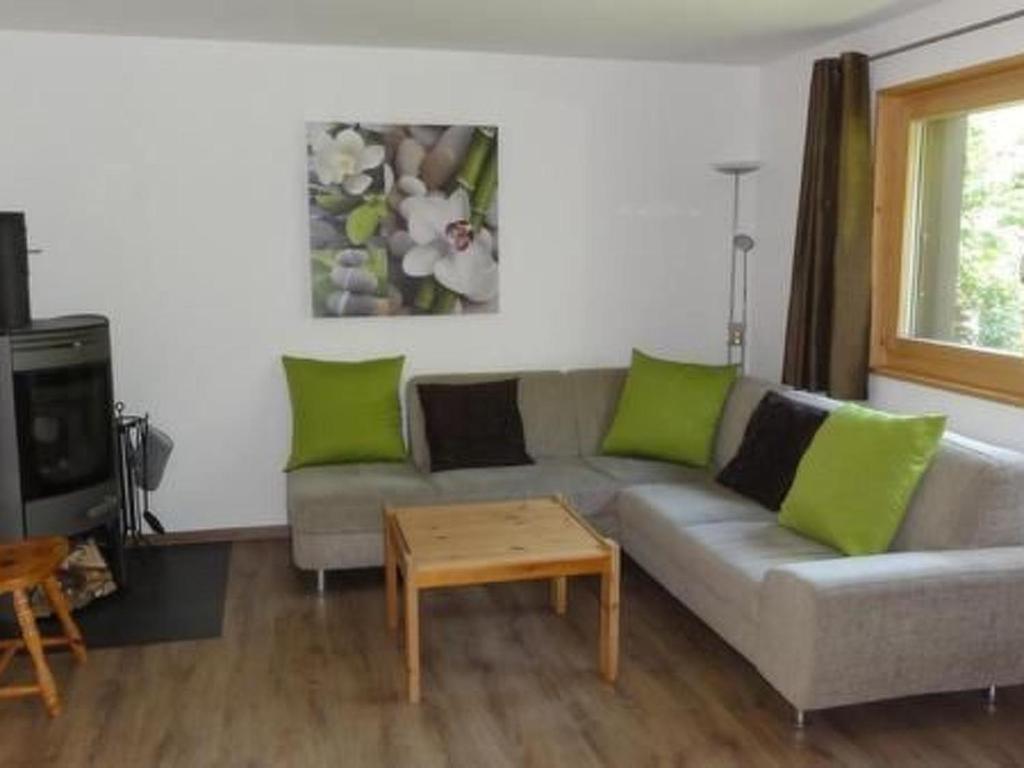 a living room with a gray couch with green pillows at Apartment Nicole 1 by Interhome in Blatten bei Naters