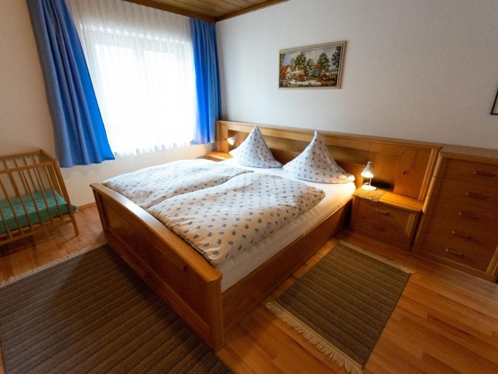 a bedroom with a bed and a window with blue curtains at Apartment Erna Angermaier by Interhome in Flattach
