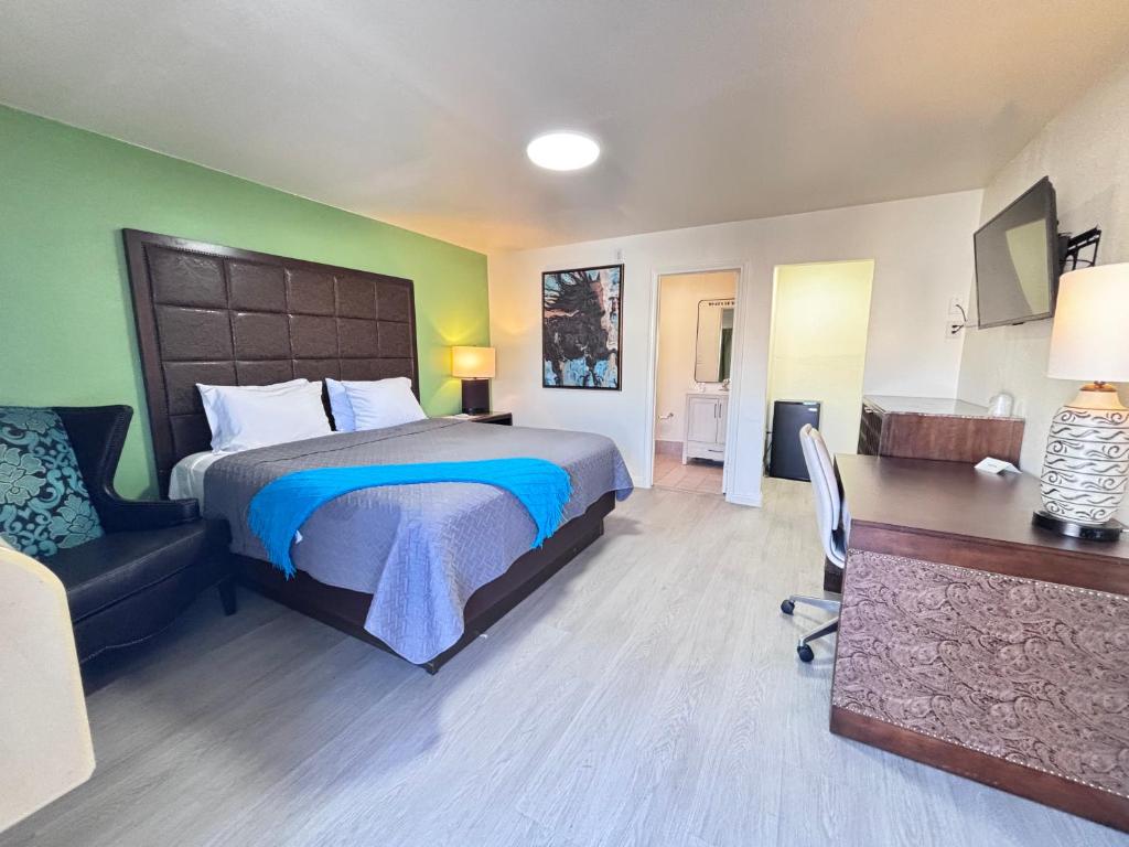 a bedroom with a bed and a desk and a chair at The Crest Motel in Corona
