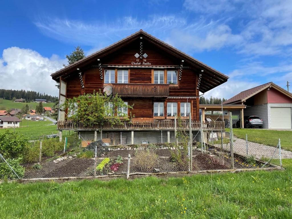 a log house with a garden in front of it at Apartment Chalet Hulda by Interhome in Heimenschwand