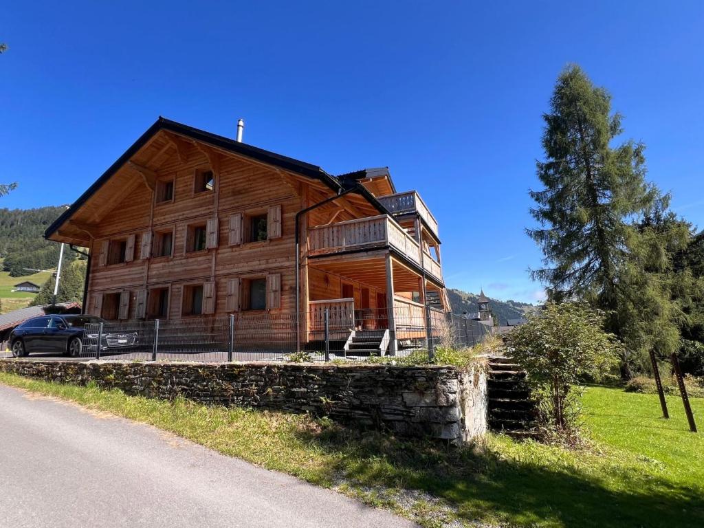 a large wooden house on the side of a road at Apartment Peak App- Morgins by Interhome in Morgins