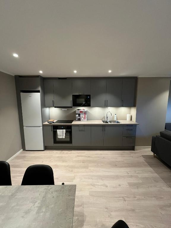 a kitchen with gray cabinets and a table in a room at Skolegata 6B, 9404 Harstad in Harstad