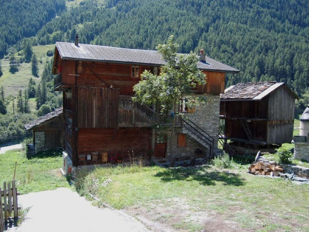 an old barn with a staircase in a field at Apartment Base Camp Evolène by Interhome in Evolène