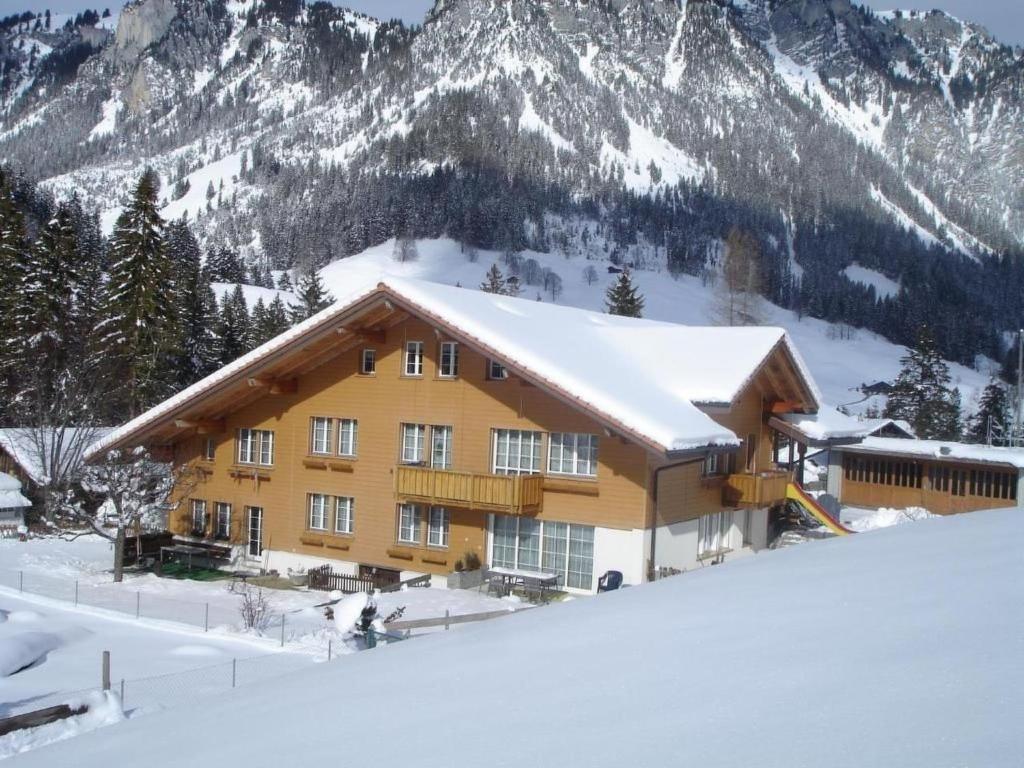 a building in the snow with mountains in the background at Apartment Appartement Eggmatte by Interhome in Grimmialp