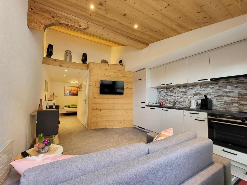 a living room with a couch and a kitchen at Apartment Chalet Lilo Studio by Interhome in Beatenberg