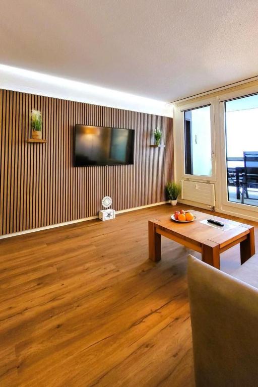 a living room with a table and a tv on a wall at Apartment Hotel Apartment by Interhome in Beatenberg