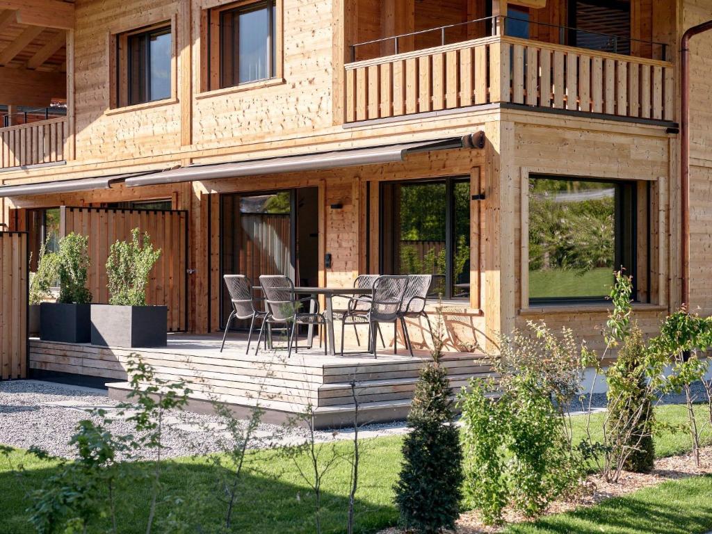 a house with a deck with a table and chairs at Apartment My Chalet by Interhome in Meiringen