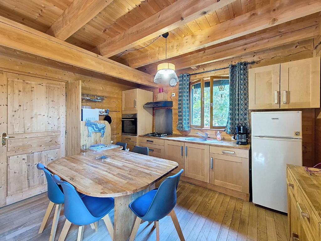 a kitchen with a wooden table and blue chairs at Chalet L'Adret in Besse-et-Saint-Anastaise