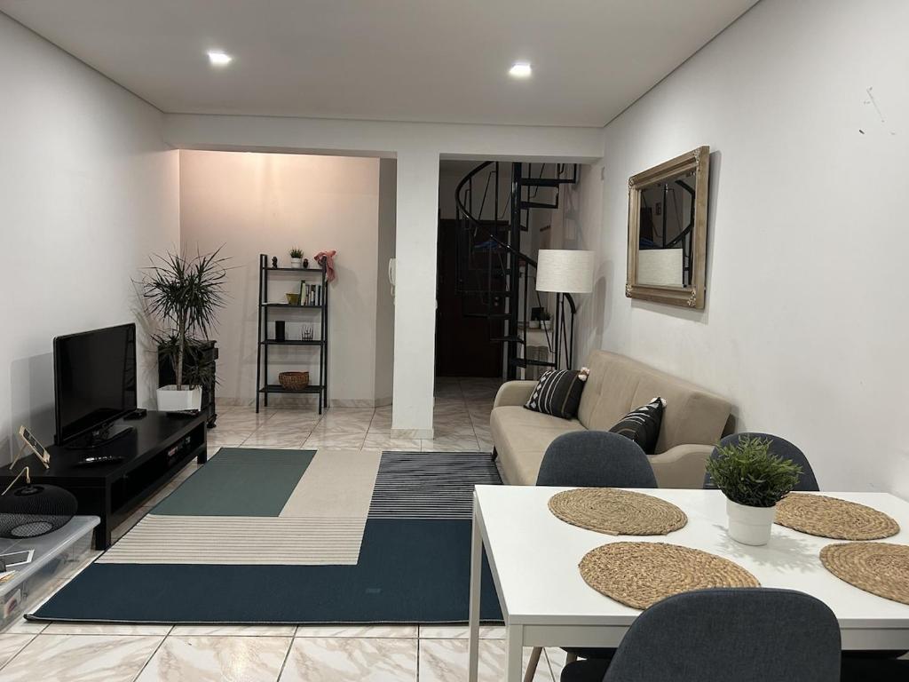 a living room with a couch and a table at Apartamento próximo da praia e do centro da cidade in Póvoa de Varzim