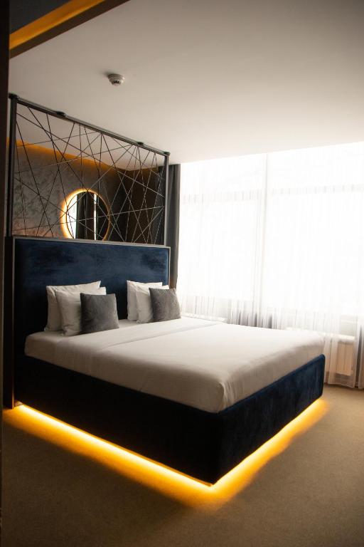 a bedroom with a large bed with lights on it at Olivia Rooms in Belgrade