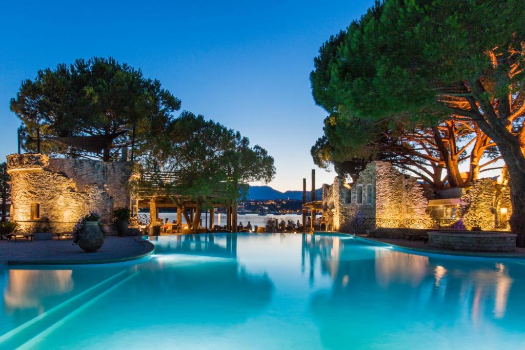 ein großer Pool mit Bäumen und blauem Wasser in der Unterkunft Hôtel Le Belvédère in Porto-Vecchio