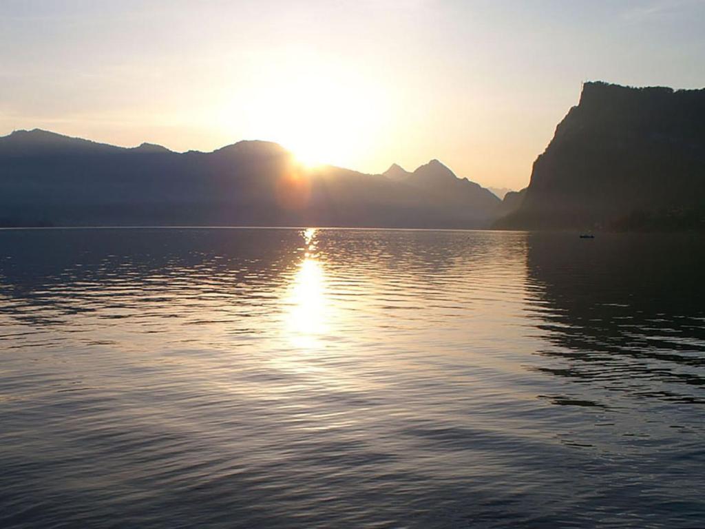 a sunset over a body of water with a mountain at Apartment Apartment 360 by Interhome in Lucerne