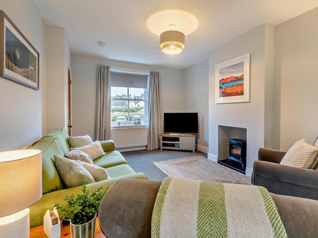 a living room with a green couch and a television at 2 Bed in Keswick oc-sz006 in Keswick
