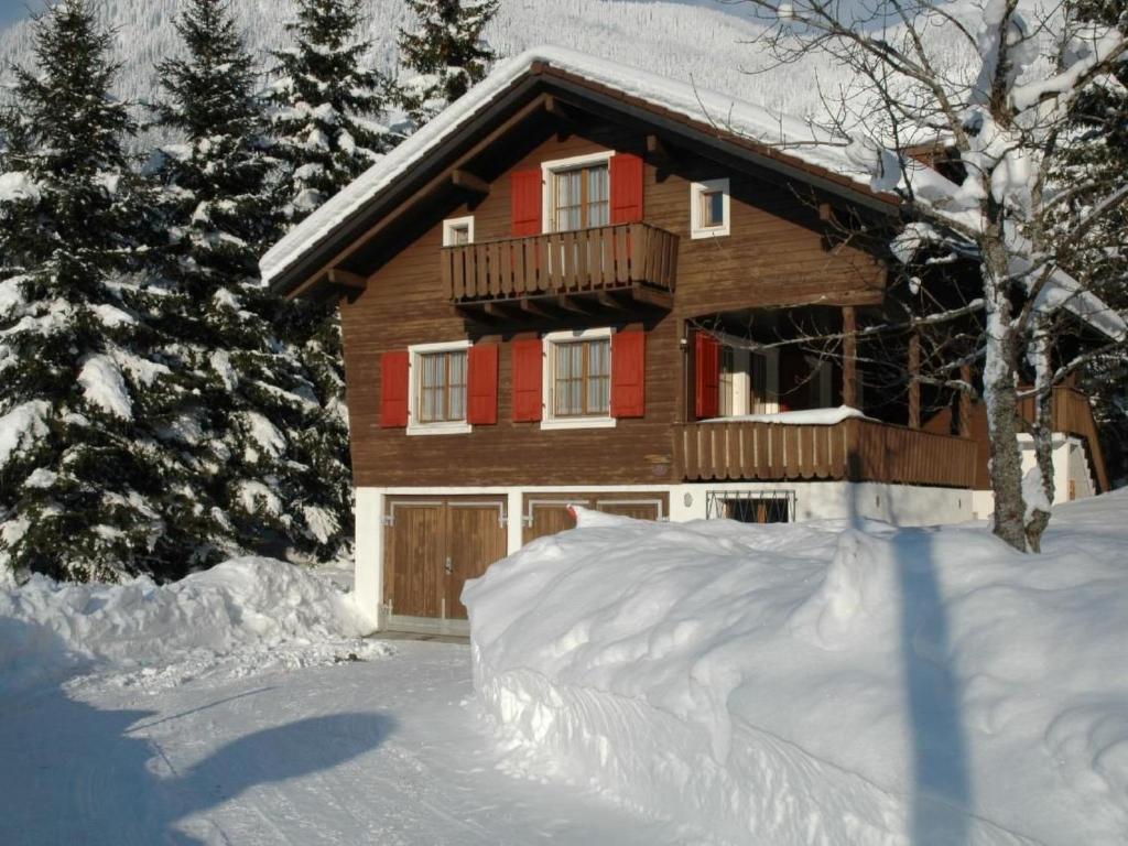 a house in the snow with a pile of snow at Apartment Chalet Bacchus - EG by Interhome in Sörenberg