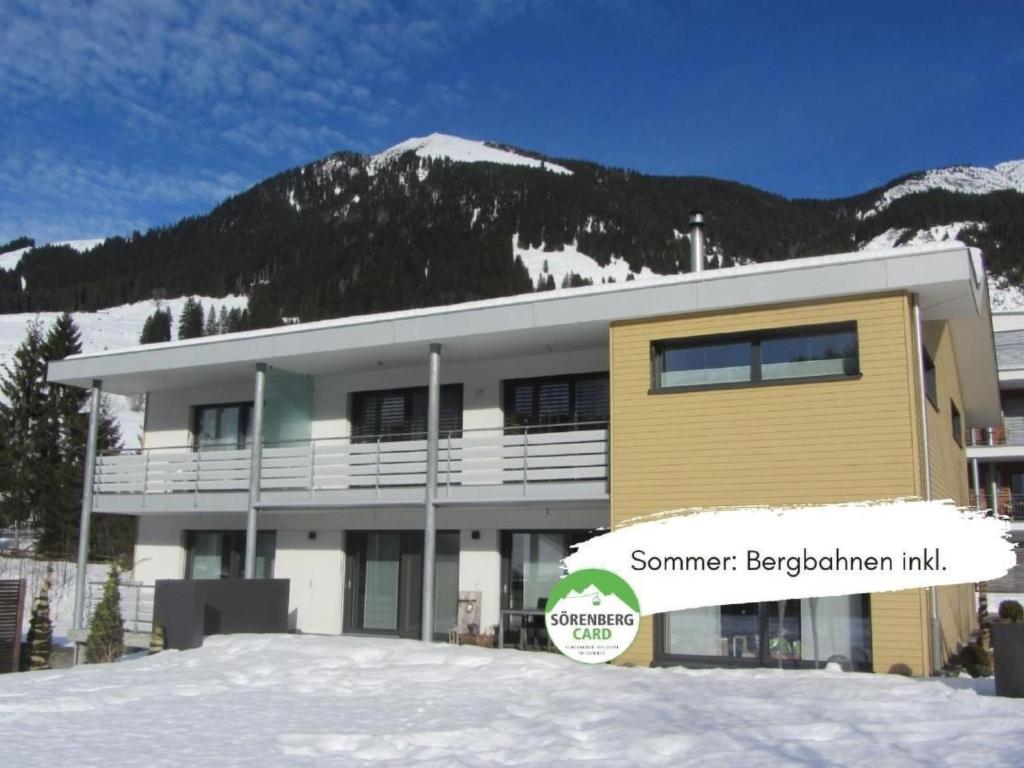 a building in front of a snow covered mountain at Apartment Lauigrund by Interhome in Sörenberg