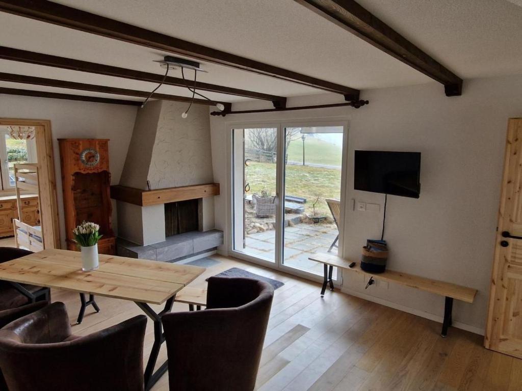a living room with a table and a fireplace at Apartment Sonnehüsli by Interhome in Flühli