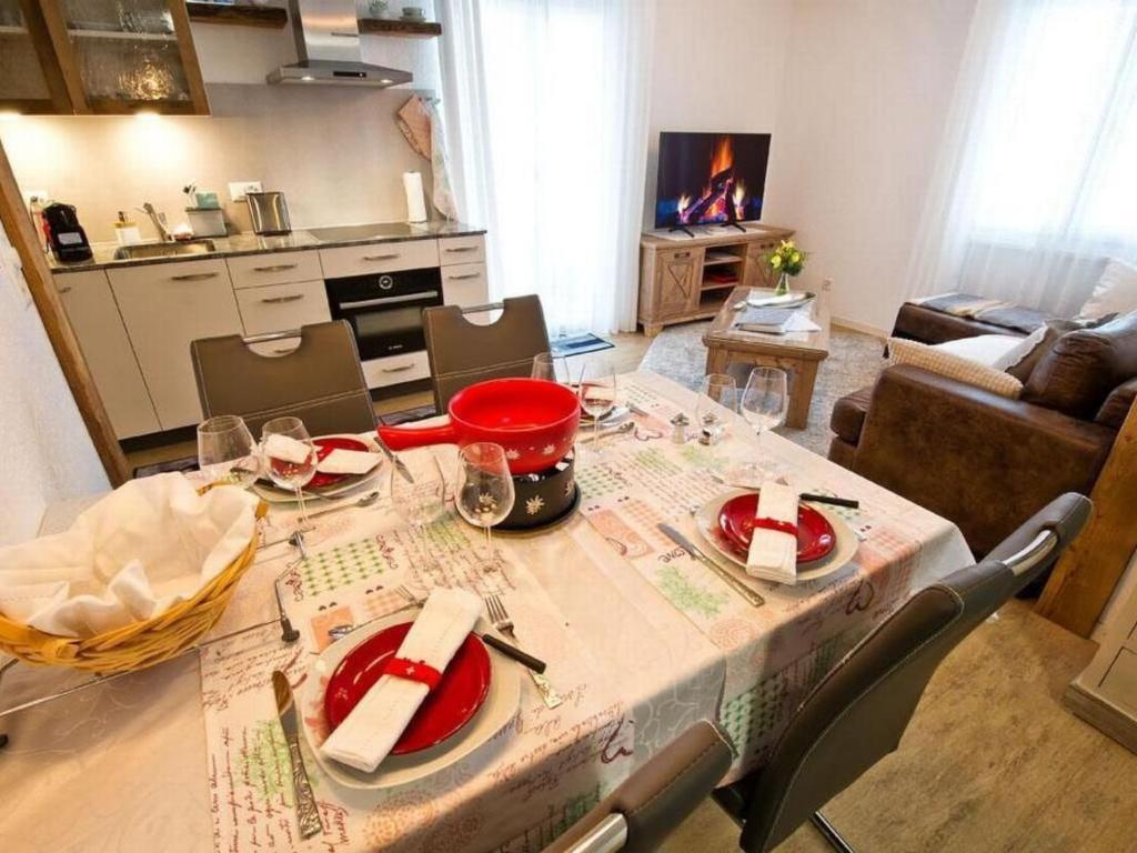 a table with red dishes on it in a living room at by Interhome in Sattel