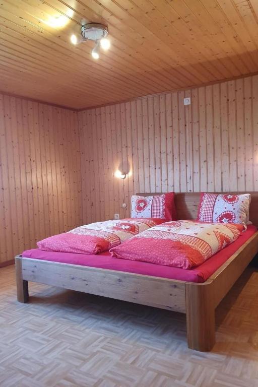 a large bed in a room with wooden walls at Apartment Fruehalp by Interhome in Unterägeri