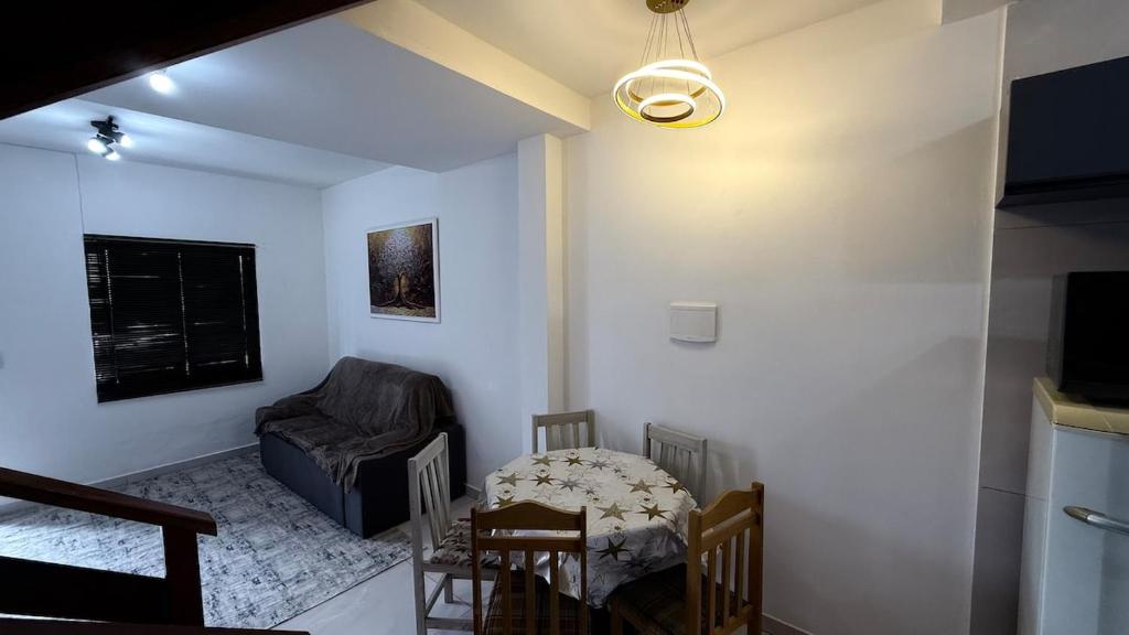 a living room with a table and a chair at Duplex completo, perto da praia e no centro de Imbé in Imbé
