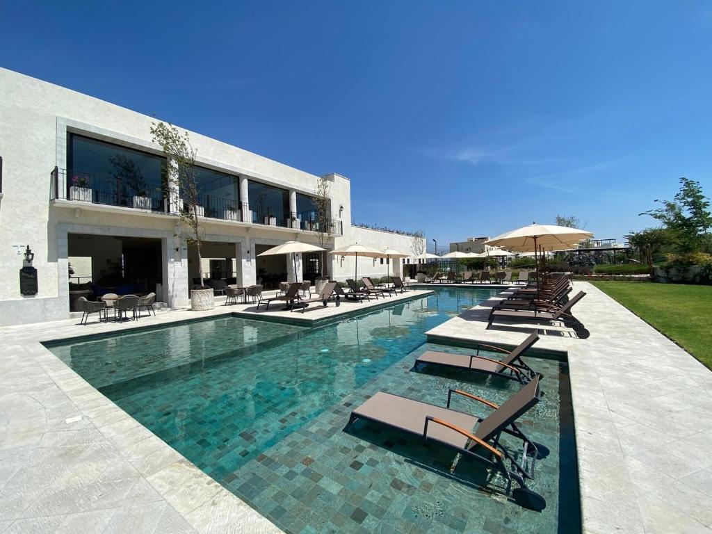 a swimming pool with lounge chairs and a building at LUMINARIA Pool, Near the Historic Center | Elegant in San Miguel de Allende