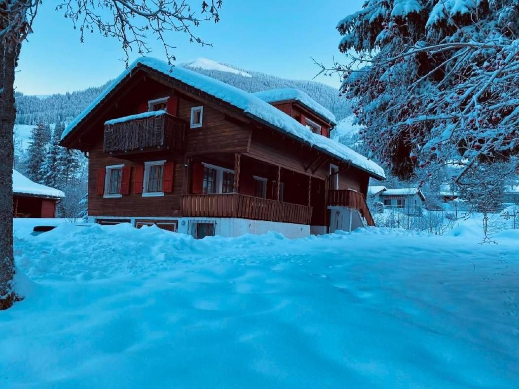 a log cabin in the snow with snow covered trees at Apartment Chalet Bacchus - OG by Interhome in Sörenberg