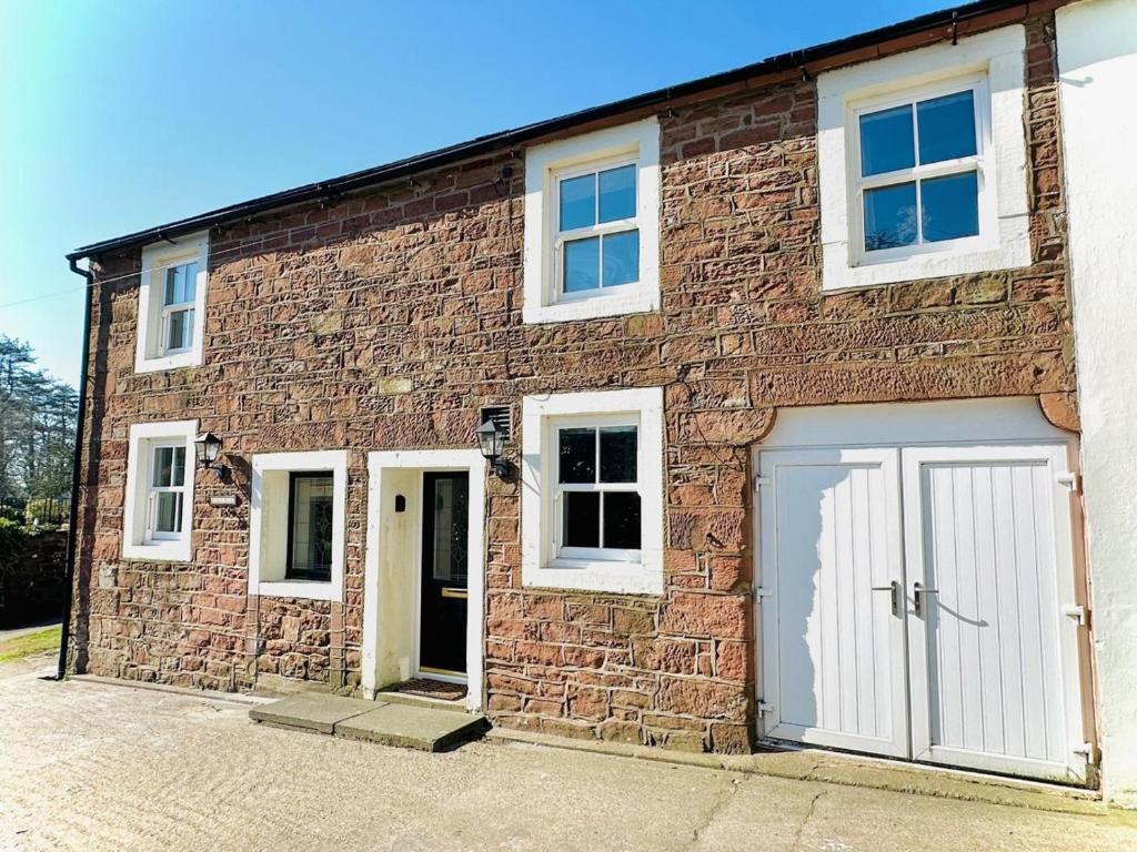 a brick building with two doors and a garage at 3 Bed in Egremont oc-90050 in Hale