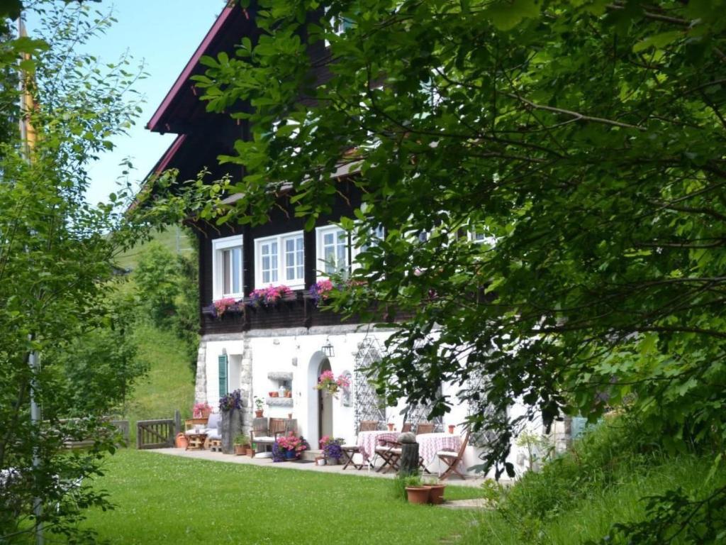 a white house with a black roof and a yard at Apartment be und mee by Interhome in Rigi Kaltbad