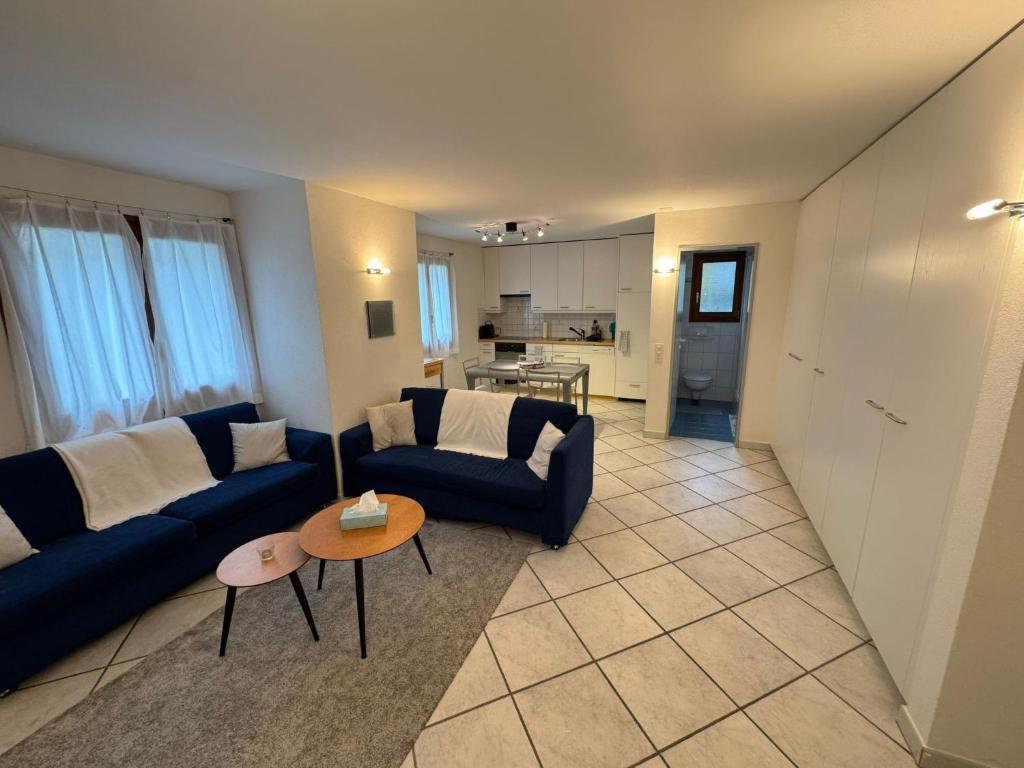 a living room with a blue couch and a table at Apartment Walserwohnung by Interhome in Bosco Gurin