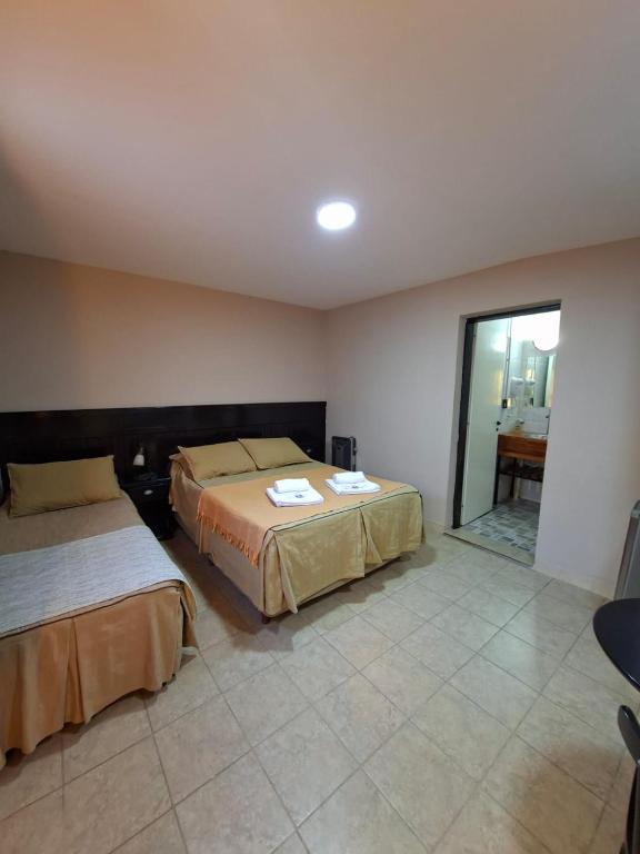 a hotel room with two beds and a table at Hosteria Marina Bella 3 in Rada Tilly