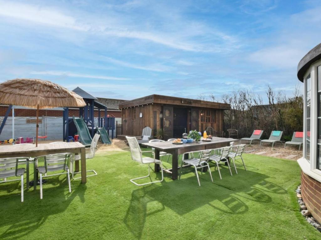 a patio with a table and chairs on grass at 6 Bed in Rye- oc-89037 in Camber