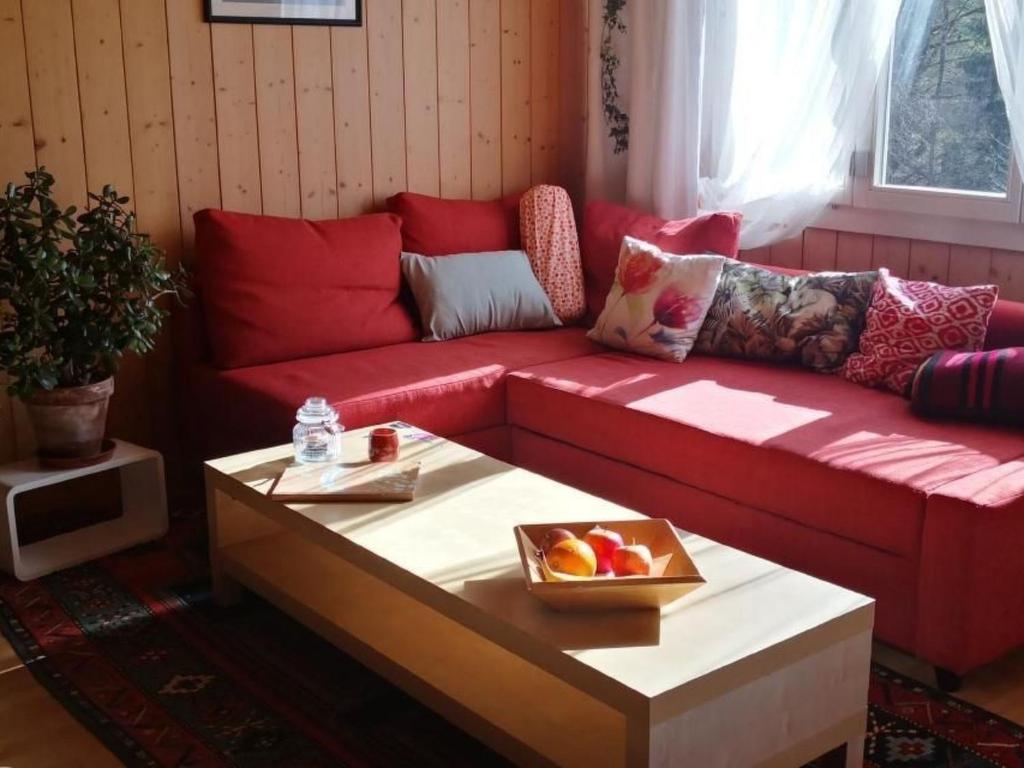 a red couch in a living room with a table at Apartment Karotte by Interhome in Trub