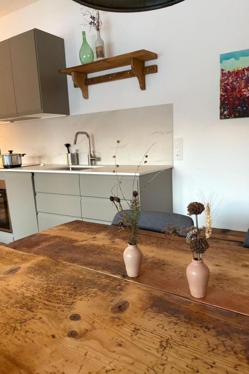 two vases sitting on a wooden table in a kitchen at Apartment Poste viglia by Interhome in Lohn
