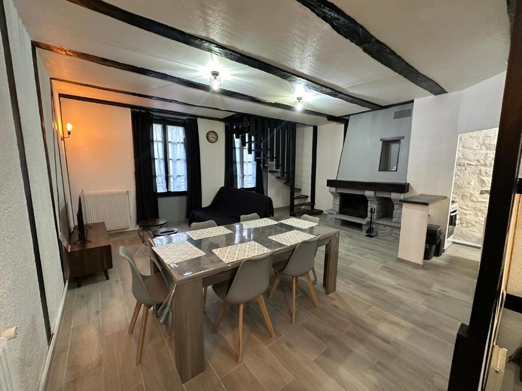 a dining room with a table and chairs and a living room at Duplex au cœur de la Bastide in Villefranche-de-Rouergue