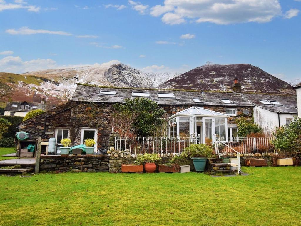 a small stone house with mountains in the background at 3 Bed in Keswick oc-94346 in Threlkeld
