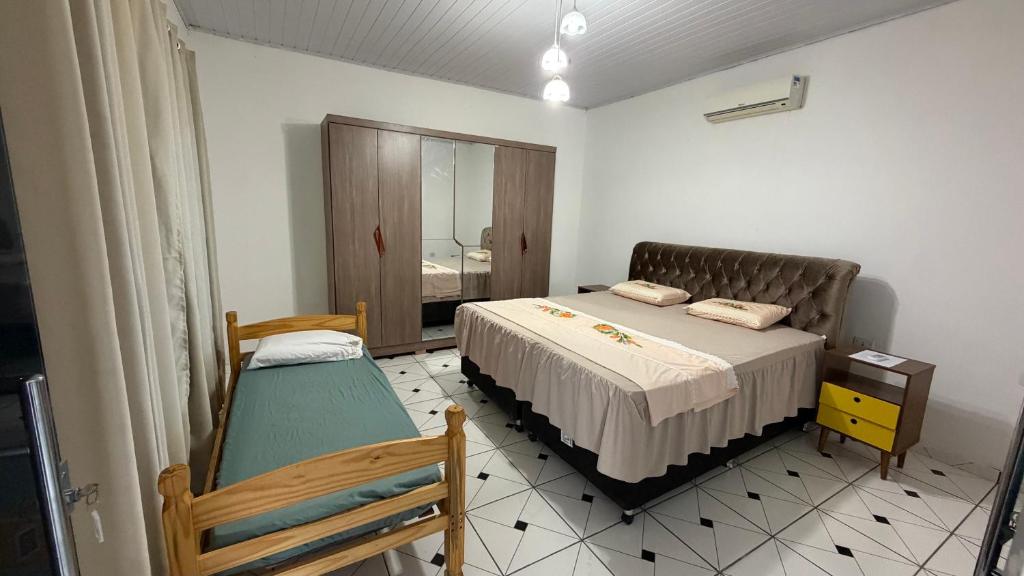 a small bedroom with a bed and a mirror at Casa inteira in Coxim