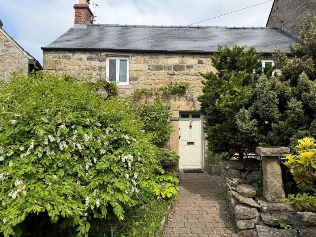 an old stone house with a white door at 3 Bed in Baslow oc-pk917 in Baslow