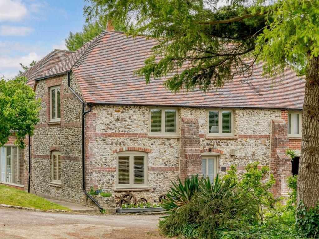 an old stone house with green shutters and a tree at 1 Bed in Wareham oc-88099 in Wool