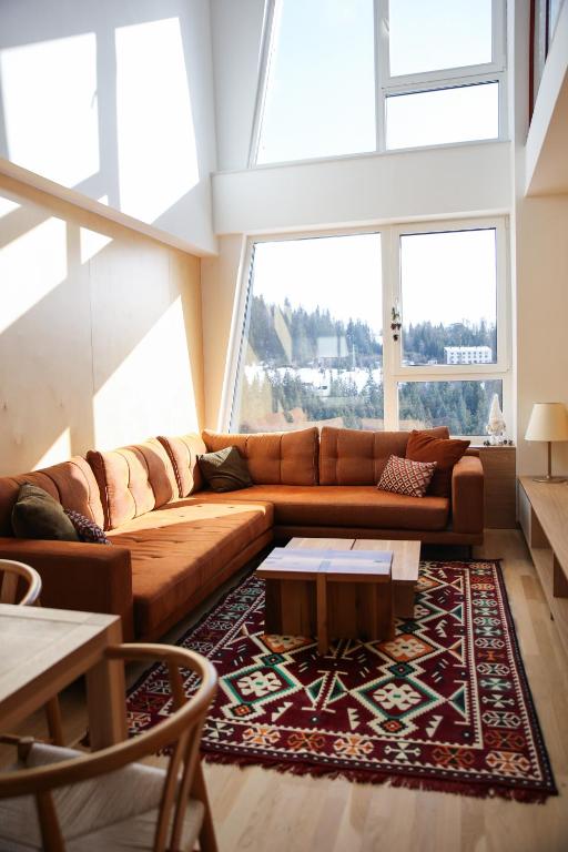 a living room with a couch and a table at A63 Premium apartment located in hotel Vucko-private host in Jahorina