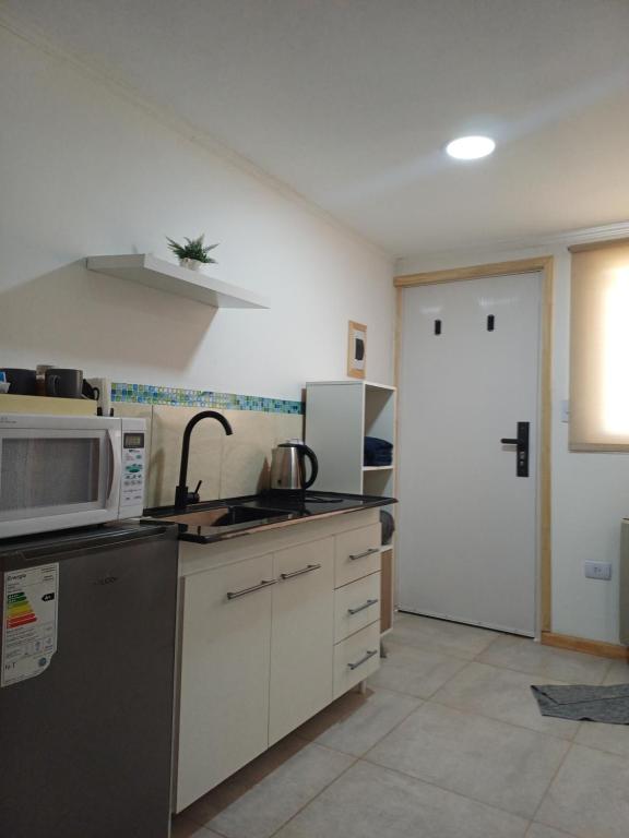 a kitchen with a sink and a microwave at Tomy in Río Grande
