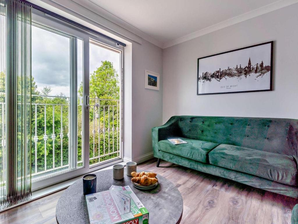 a living room with a green couch and a large window at 2 Bed in Freshwater oc-94561 in Freshwater