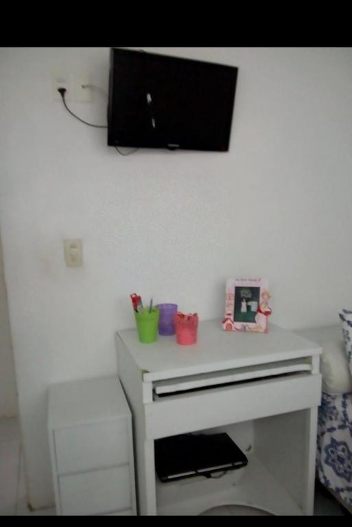 a white desk with a tv on the wall at Casa na várzea Quarto 1 in Recife